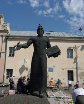 Socha jednoho z národních buditelů. Okolo místní lidé na zemi nabízejí své knihy. 