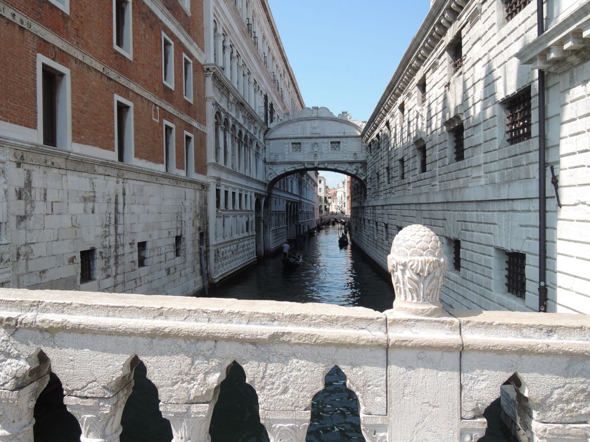 Spojovací Most Vzdechů mezi dóžecím palácem a vězením. Kanál Rio di Palazzo, skrz nějž pluly lodě se slámou