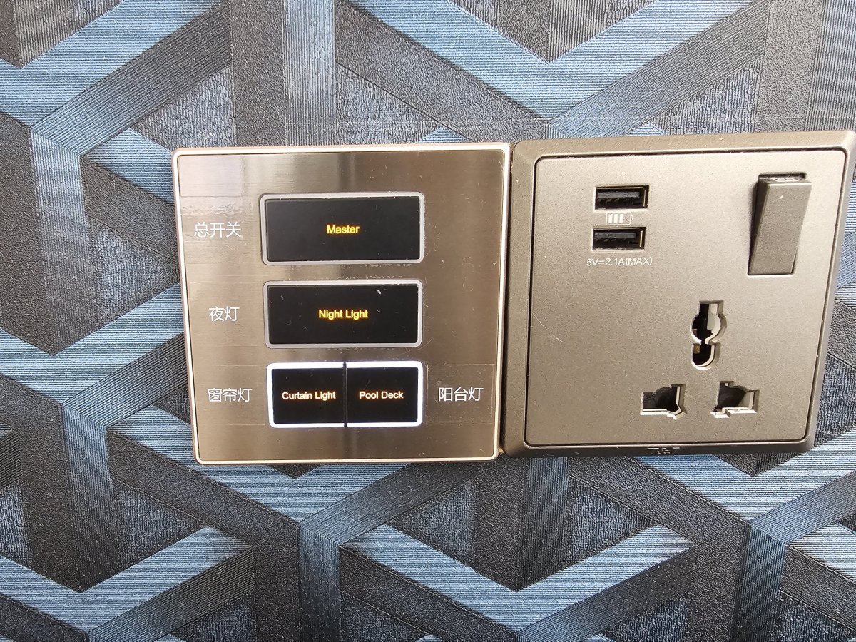 Ovládání osvětlení, závěsů a zásuvka u postele