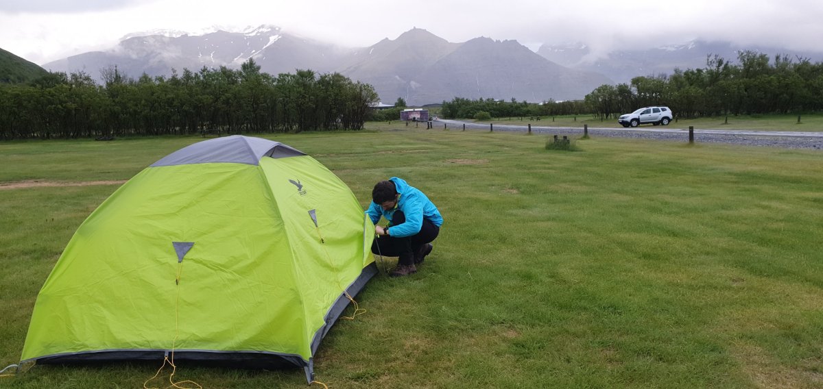 Stavíme stan, hory s ledovci v oparu mraku.