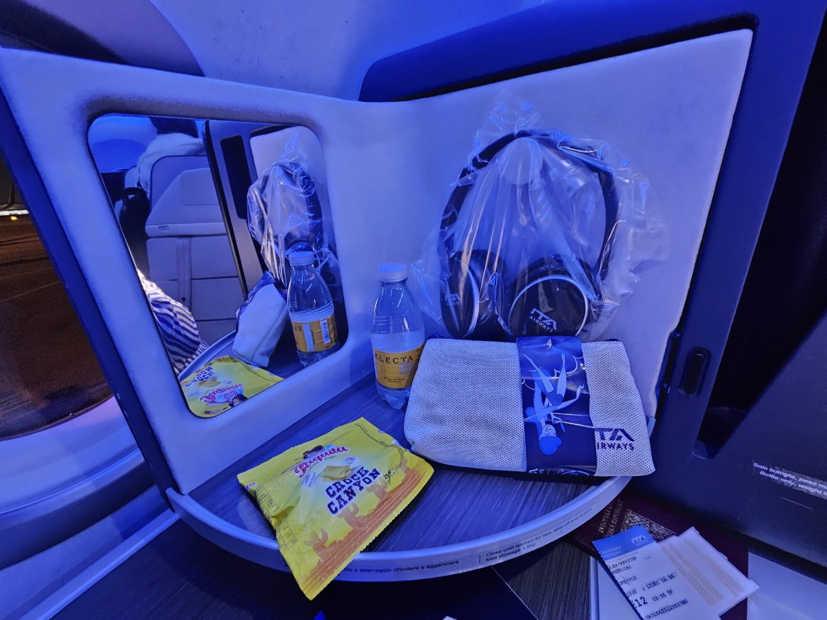 Otevírací panel se zrcadlem, sluchátky, sušenkami a vodou