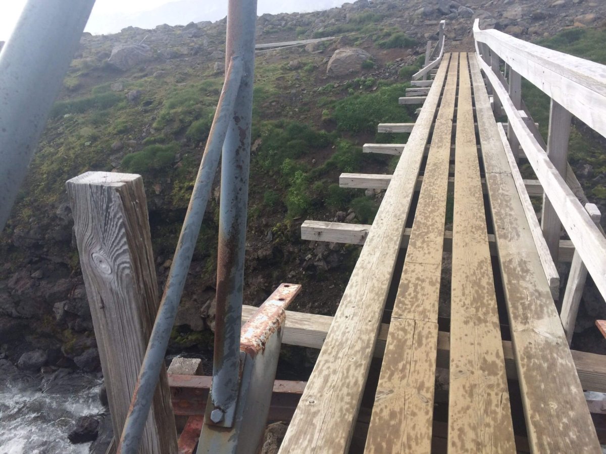 Polorozpadlý most přes řeku, který bylo nutno přejít