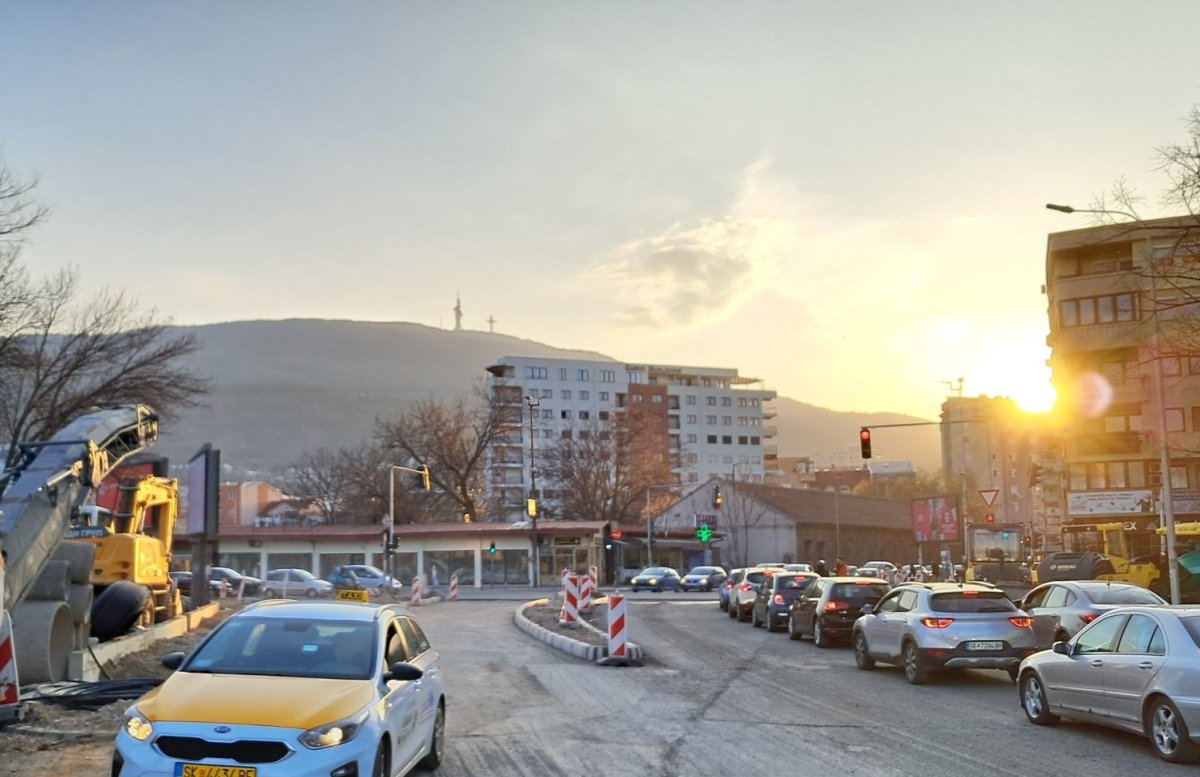 Rozkopané ulice a v pozadí hora s křížem