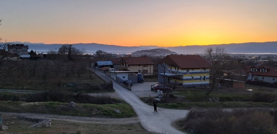Z procházky po večerním Ohridu pod kopci. V dáli je vidět kopec s pevností a hladina jezera. 