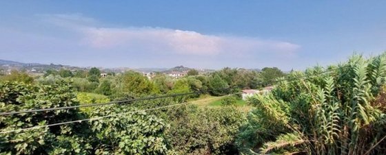 Pohled na úžasnou krajinu z venkova a zelenou vegetaci z okna vlaku. V dáli nad horami je bouřka. Vpravo je vidět travina- něco 