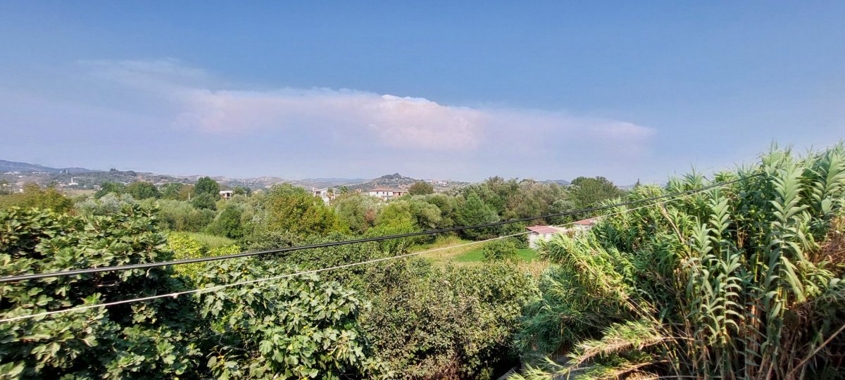 Pohled na úžasnou krajinu z venkova a zelenou vegetaci z okna vlaku. V dáli nad horami je bouřka. Vpravo je vidět travina- něco 